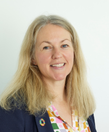 Head and shoulders photo of woman with blonde hair smiling at the camera.