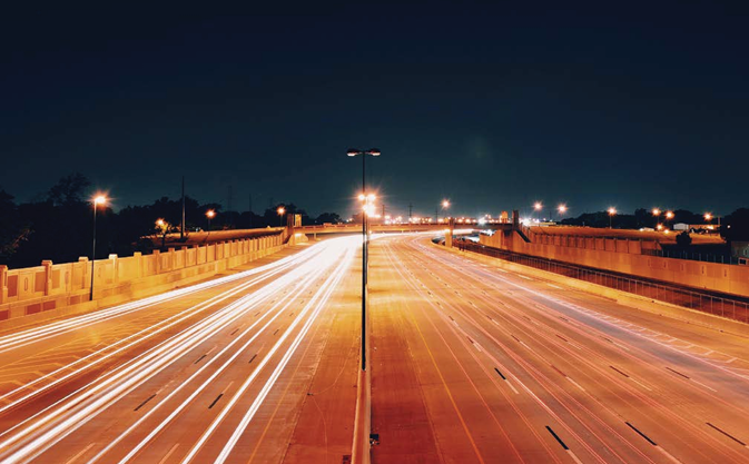 Cover image of noise research report, showing cars driving down motorway at night time