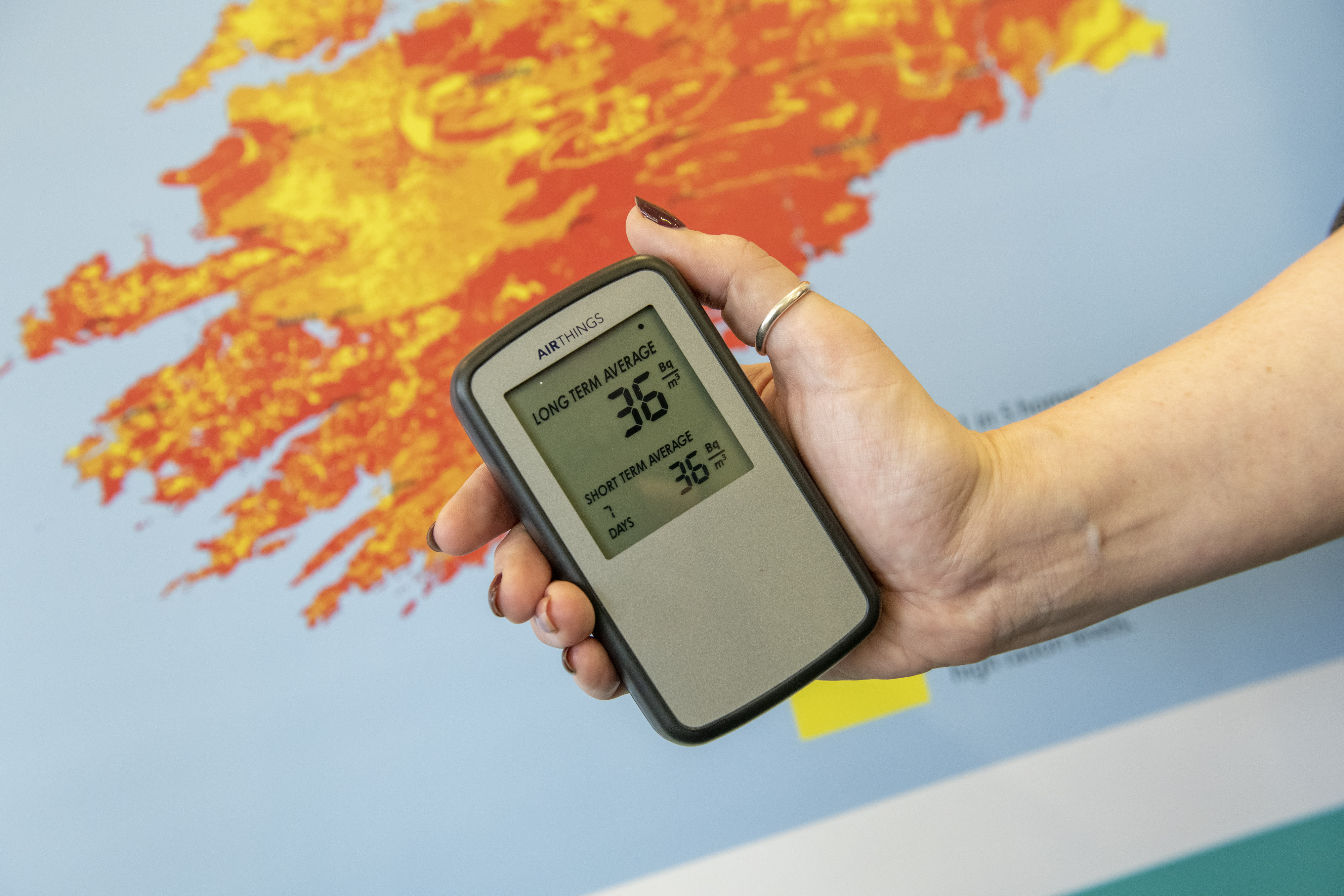 A picture of someone holding a digital radon monitor