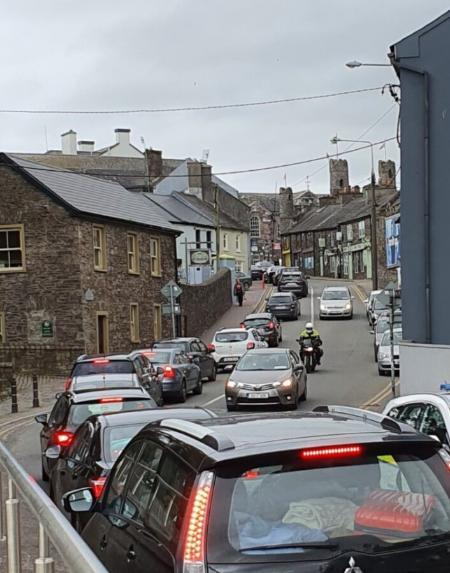 Image of cars sitting in traffic in a town or village