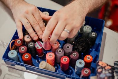 A pair of hands organising spools of thread