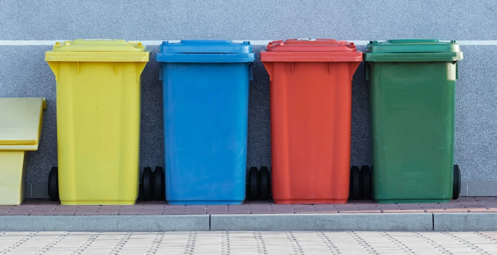 Image of five bin in difference colour against a grey wall