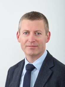 Decorative headshot of David Flynn smiling at the camera